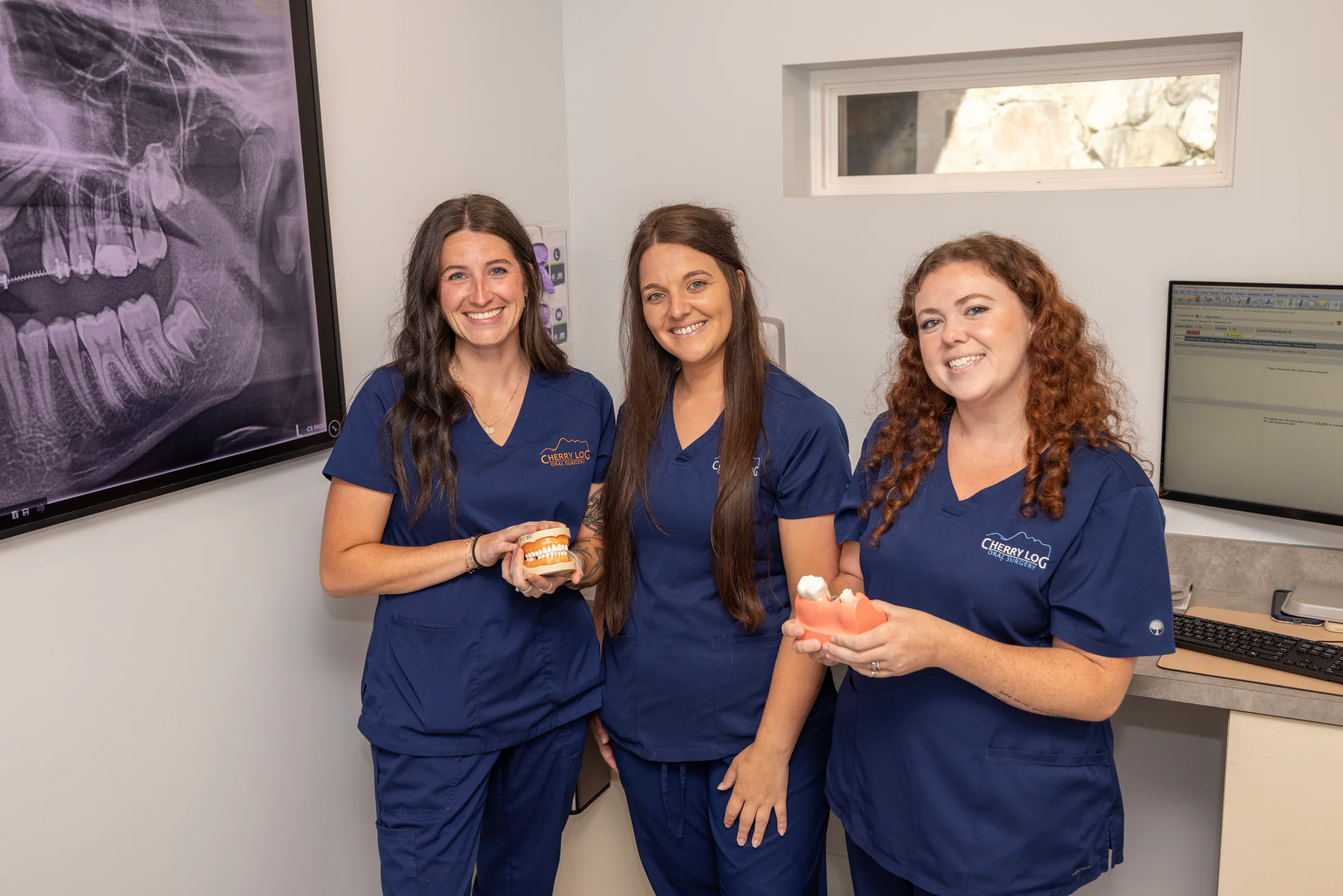 Cherry Log Oral Surgery clinical team holding dental models