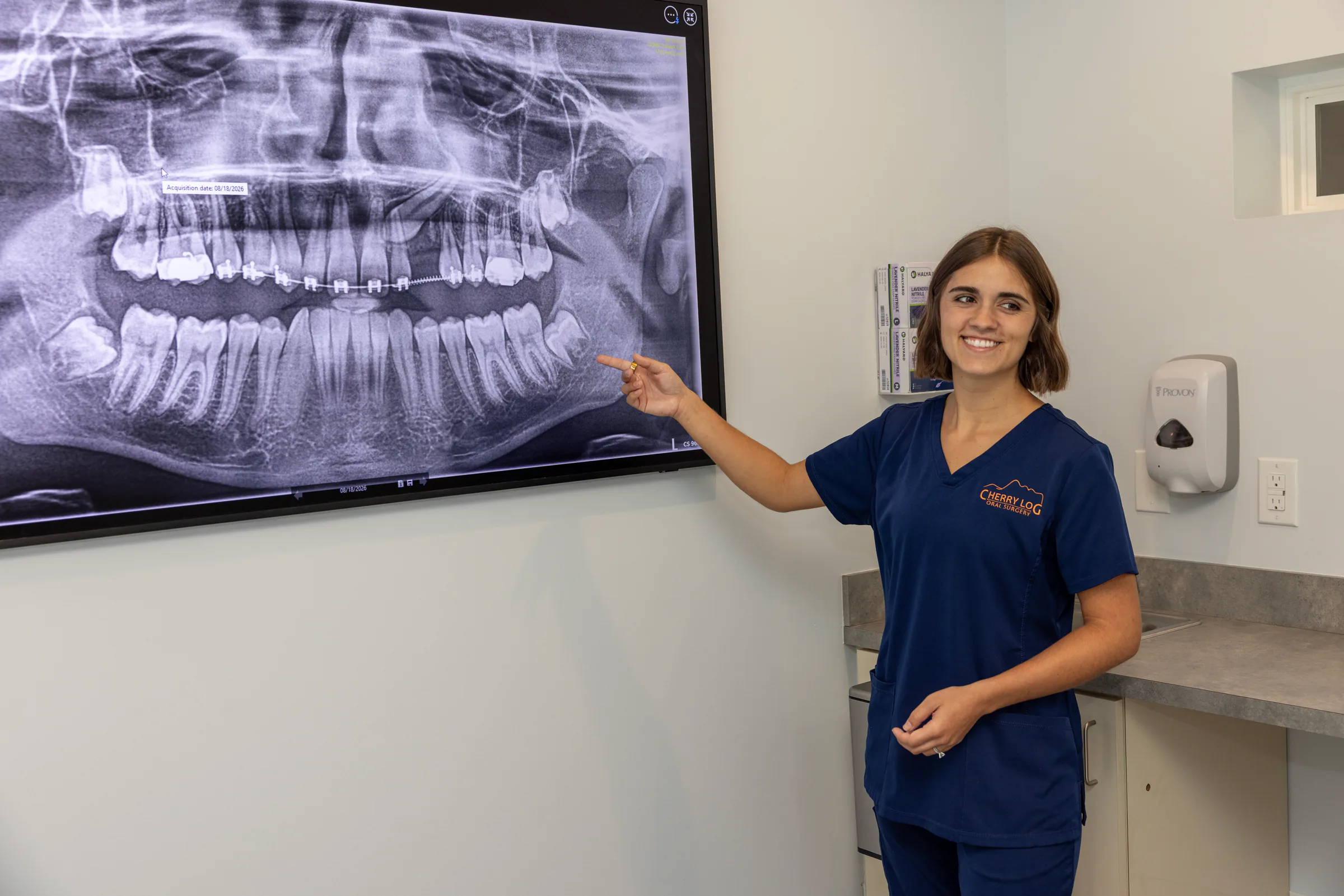 Team member pointing out wisdom teeth on a panoramic X-ray