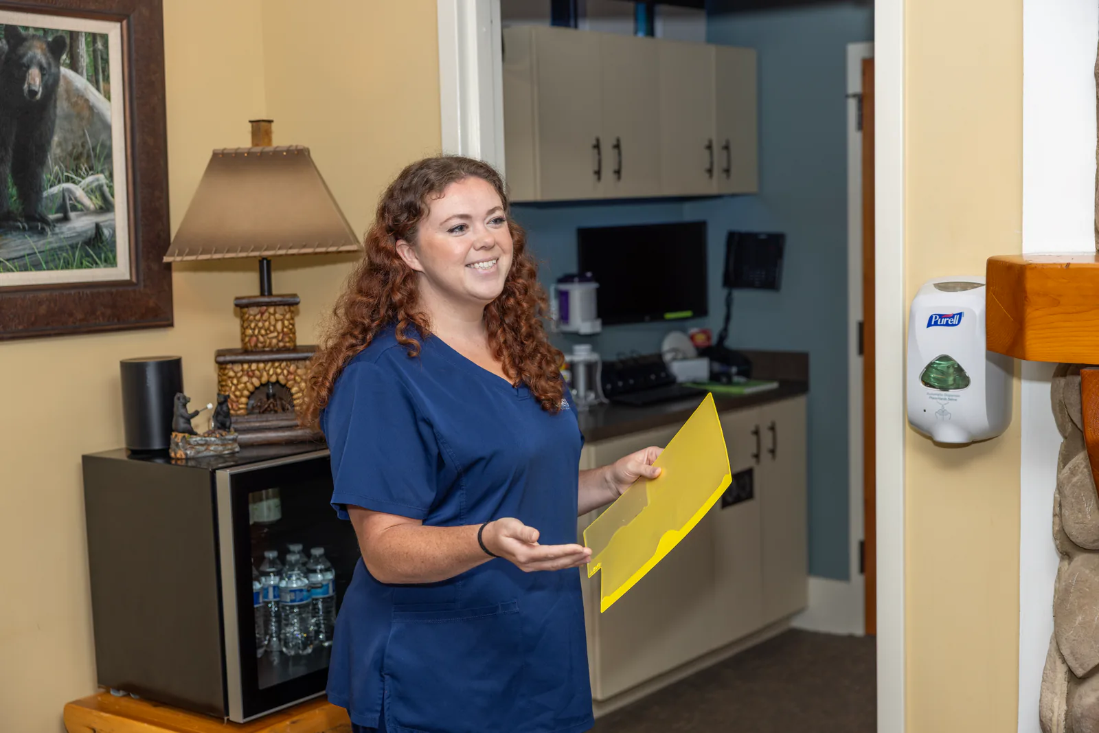 Cherry Log Oral Surgery team member welcoming a new patient with paperwork
