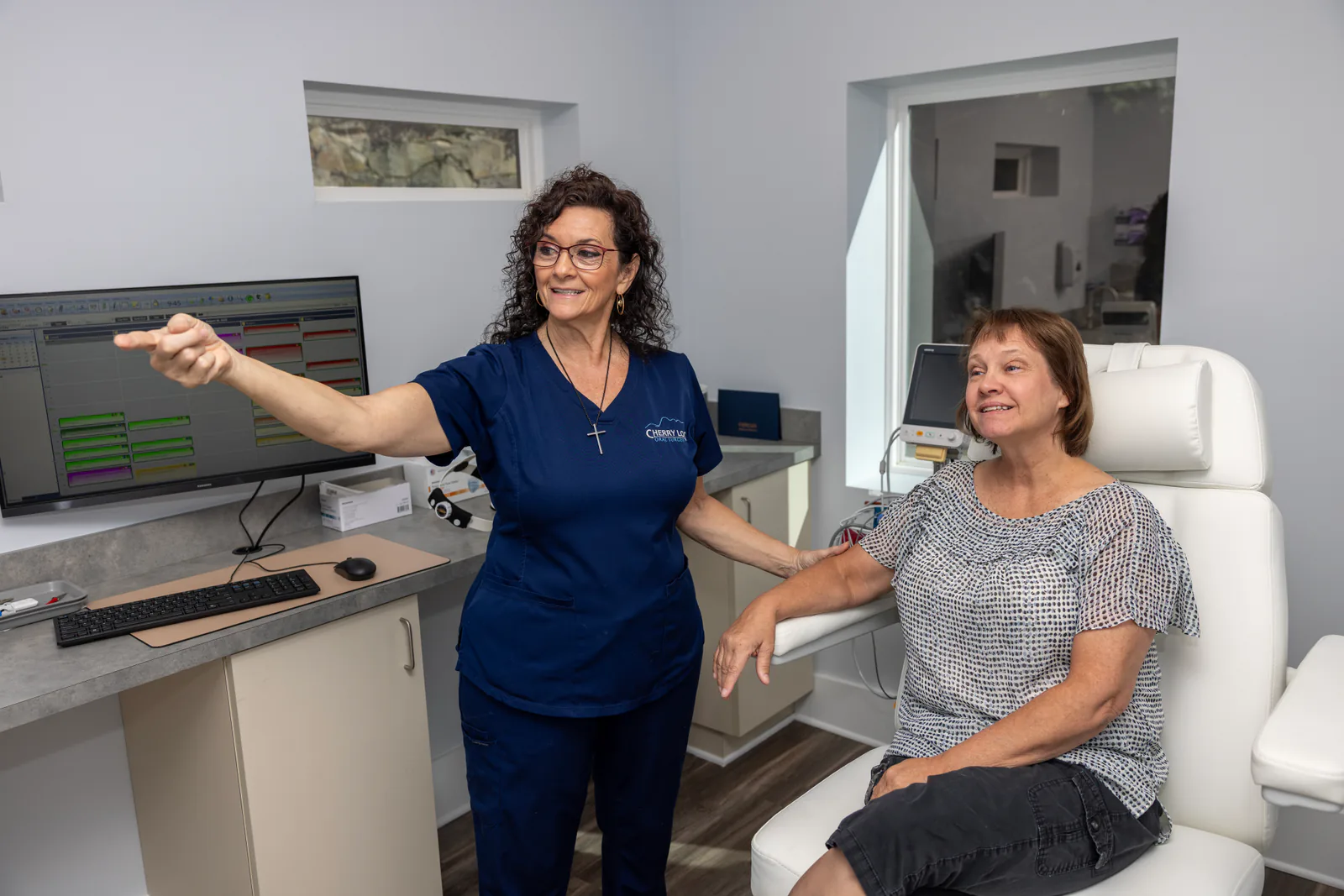 Cherry Log Oral Surgery team member showing a patient around a modern treatment room