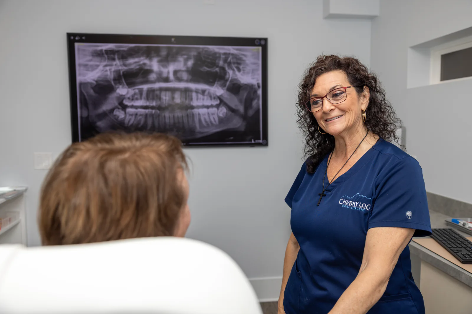 Team member reviewing panoramic X-ray imaging with a patient during treatment planning